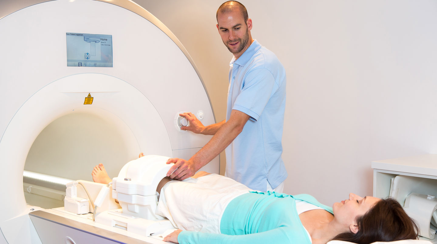 Gros plan sur un cliché d'IRM du genou posé sur une surface médicale claire avec un stéthoscope flou en arrière-plan